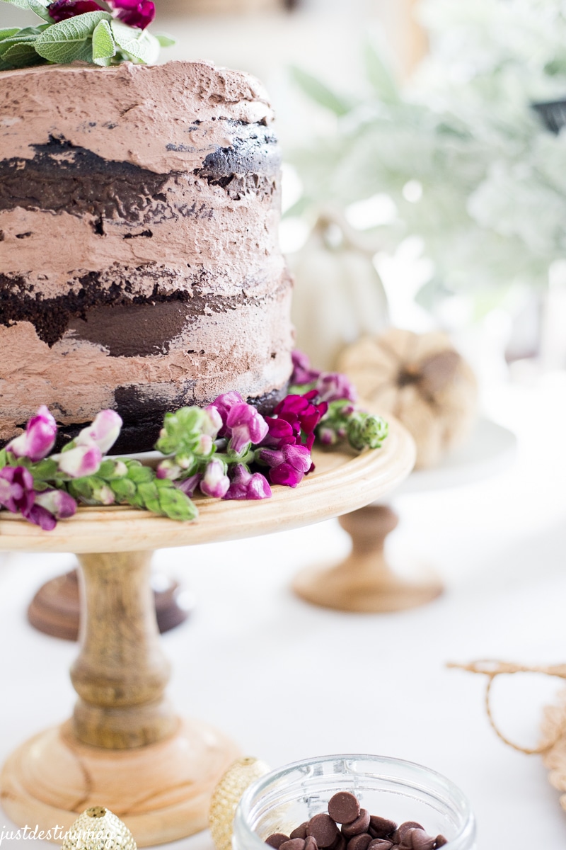 Close up of chocolate cake on a wood stand with purple flowers