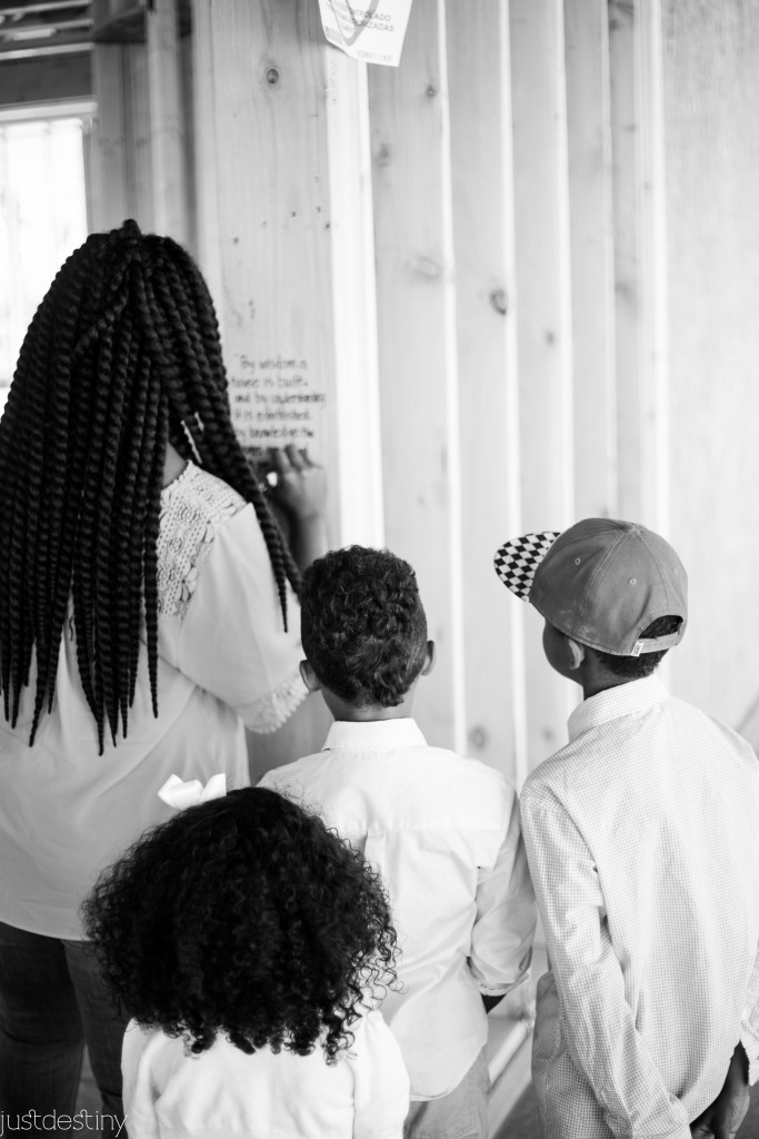 Kids gather around while mom writes bible verses on their new home