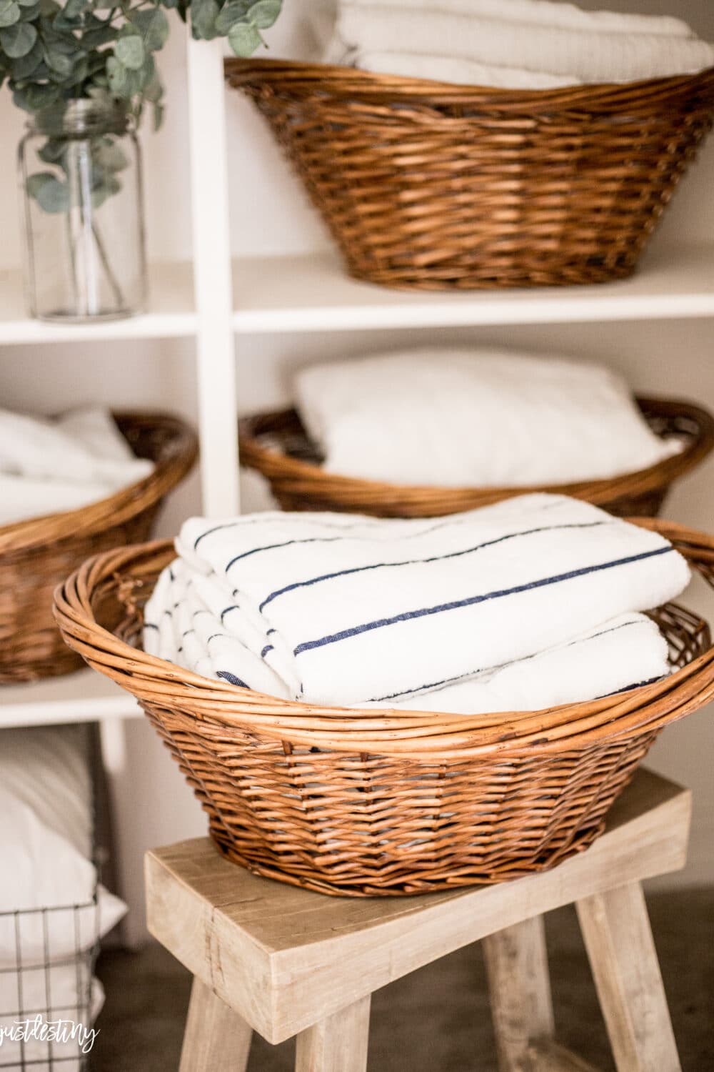 Linen closet with pool and bath towels in basket 