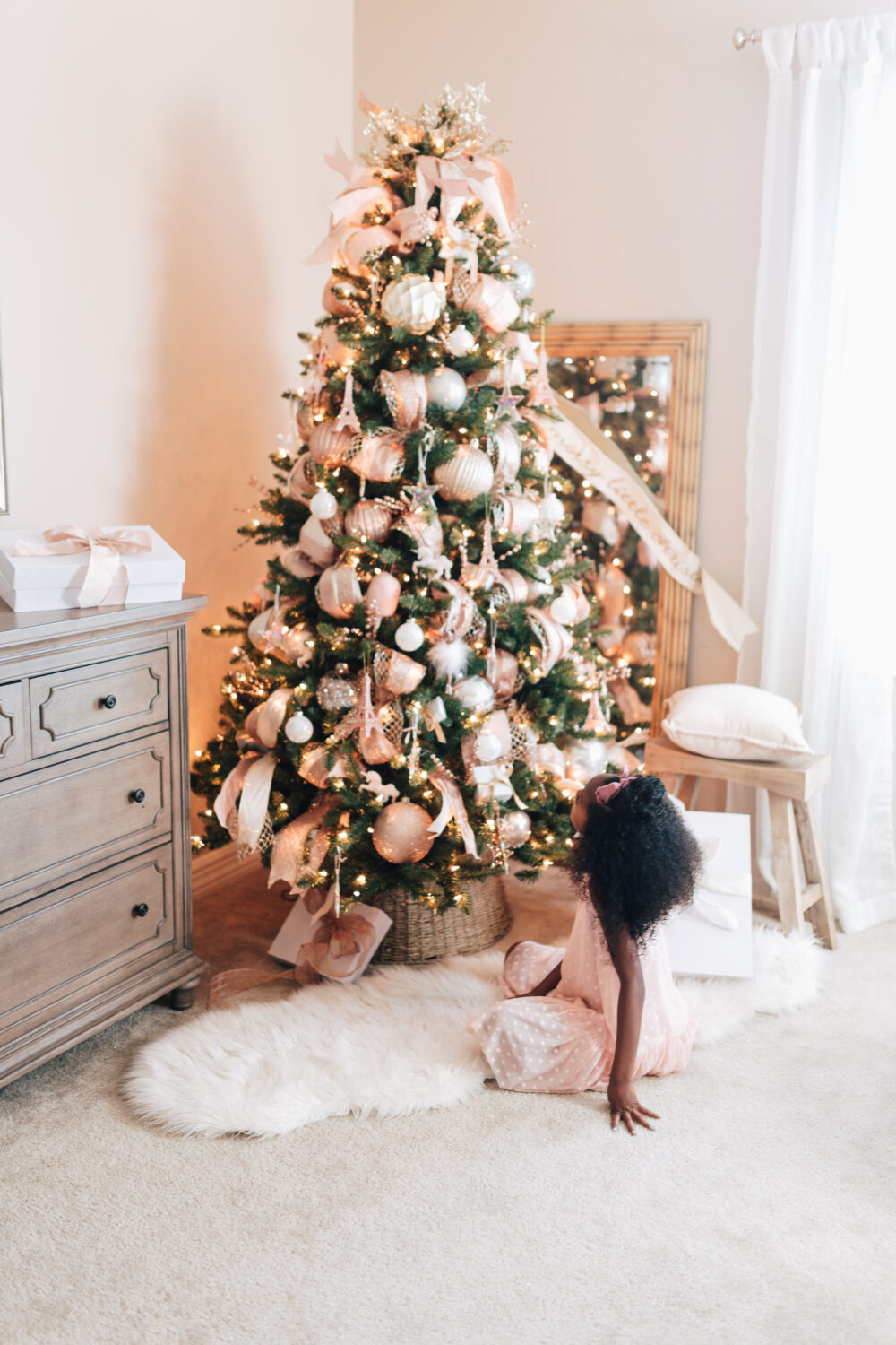 Pink Christmas tree decorations for a little girls room. Very pretty. It has pink ribbon and ornaments on a pre lit green Christmas tree