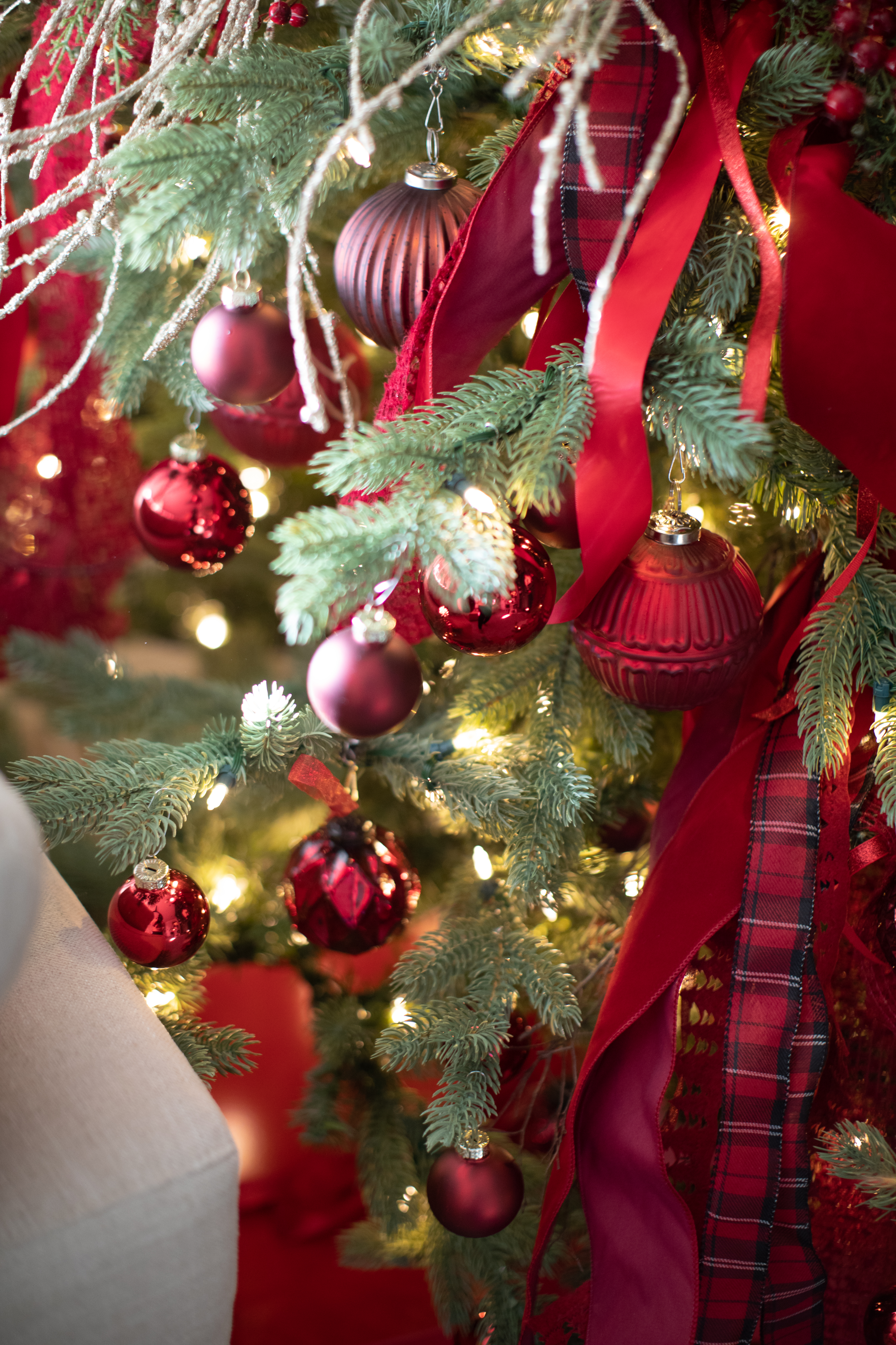 Red Christmas Tree Decor with red ribbon and ornaments on a green tree