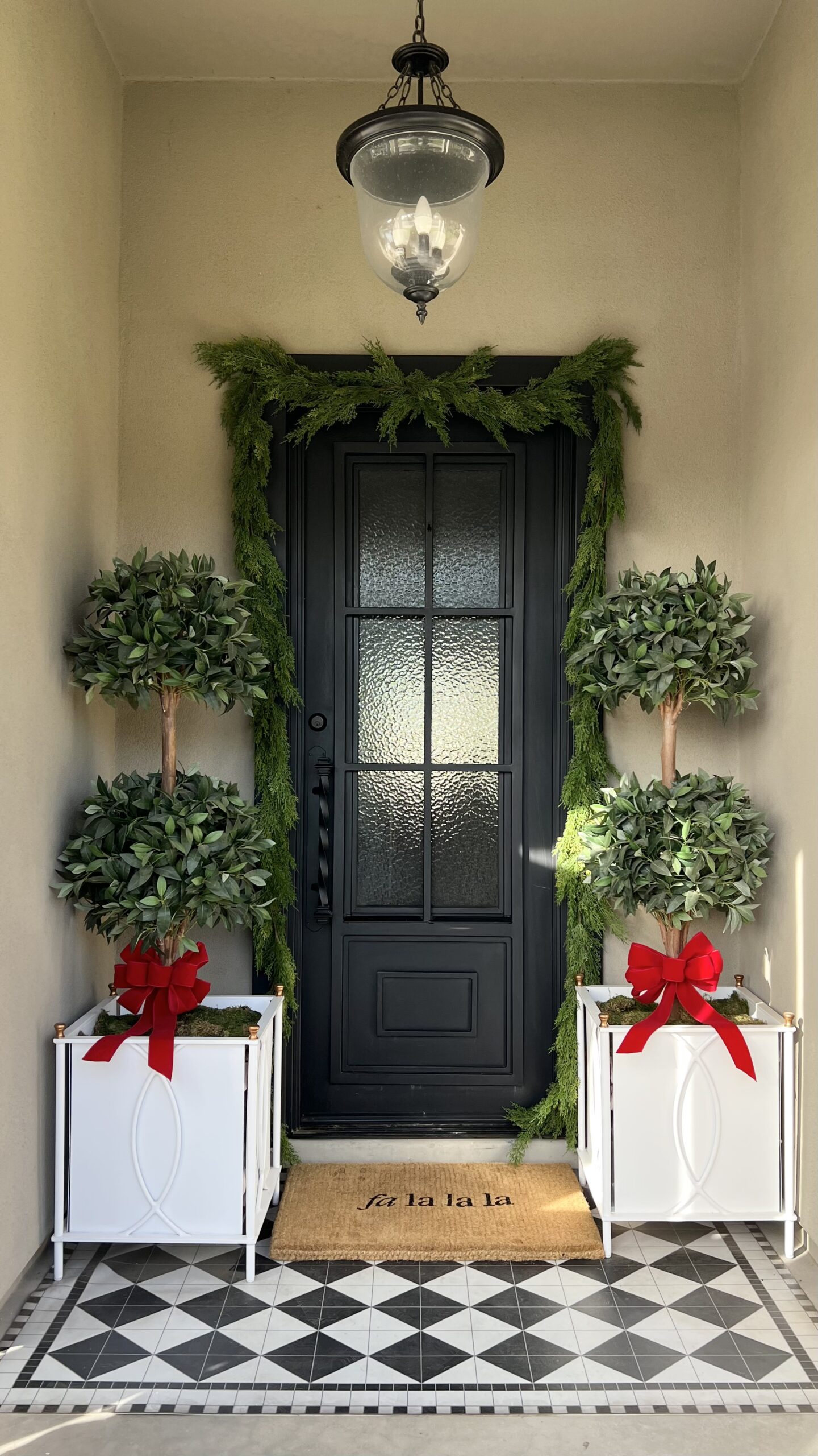 Front door decorated for Christmas. Red ribbons and garland.