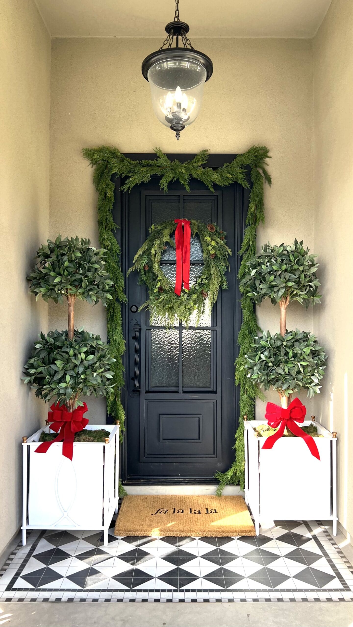 Christmas Front door with red accents and white planters.