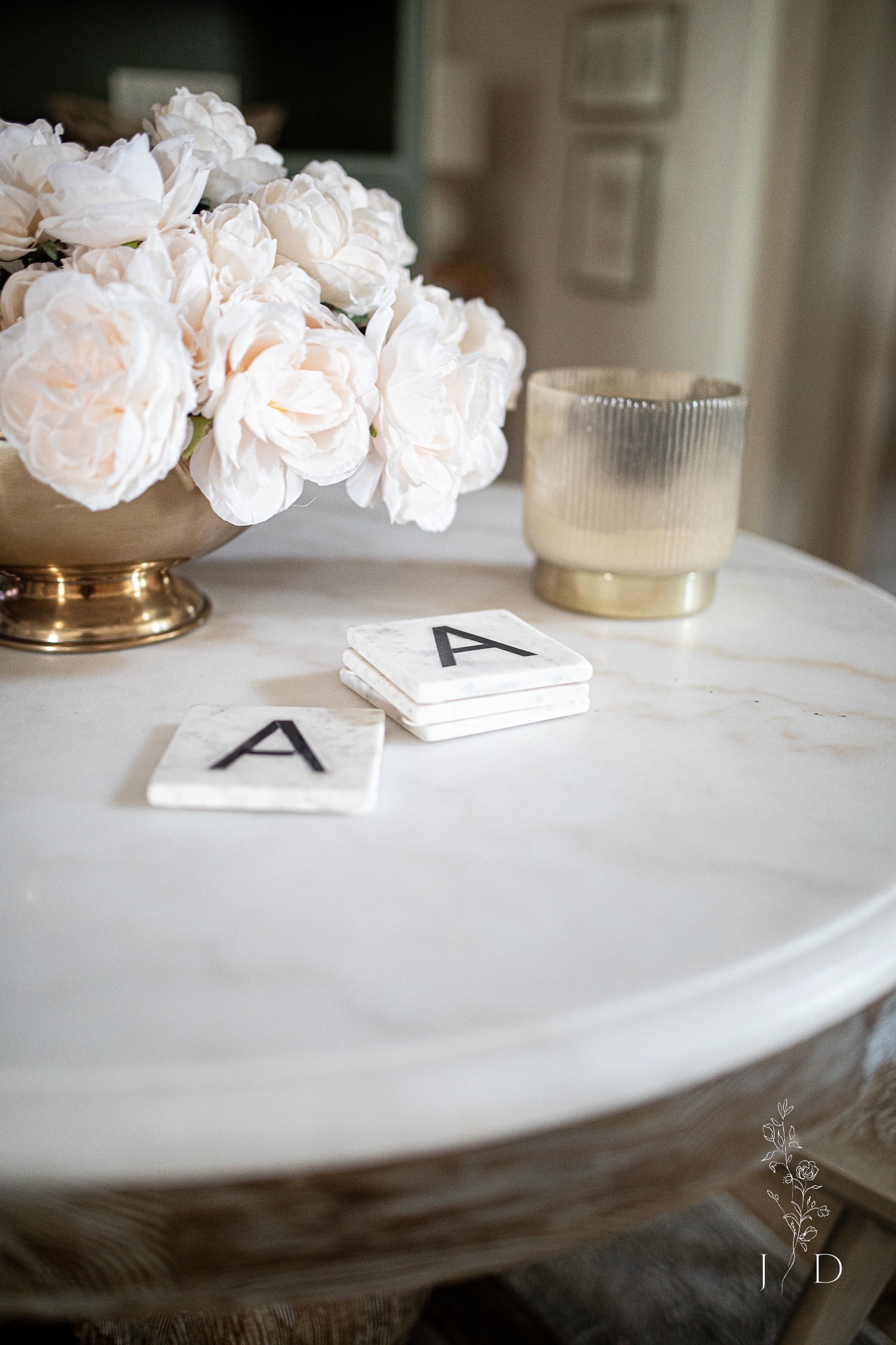 Warm white faux roses on a marble table from Arhaus 