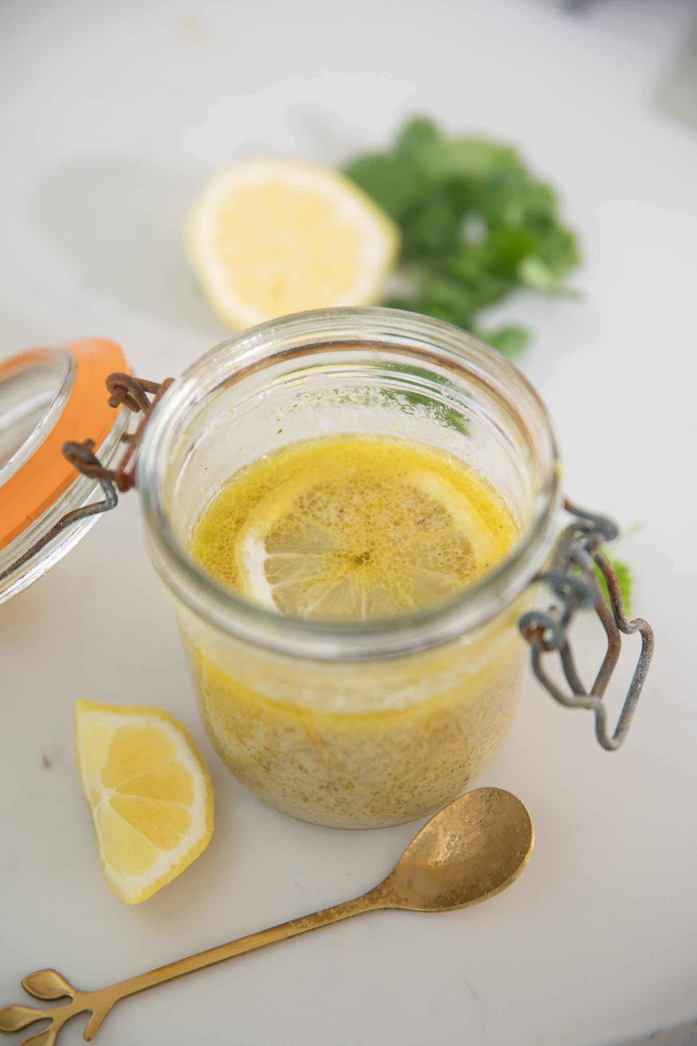 Lemon Vinaigrette with fresh lemons inside the jar